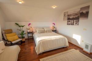um quarto com uma grande cama branca e uma cadeira em Holiday home in Smarjeske Toplice - Kranjska Krain 45723 em Smarjeske Toplice
