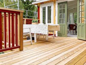 une terrasse en bois avec une table et des chaises sur une maison dans l'établissement 5 person holiday home in H RADSB CK, à Ryd