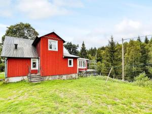 une maison rouge au sommet d'une colline herbeuse dans l'établissement 5 person holiday home in H RADSB CK, à Ryd