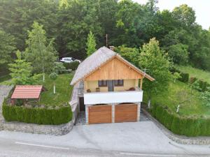 ein kleines Haus mit einer Holzgarage im Hof in der Unterkunft Holiday home in Dragatus - Kranjska Krain 45721 in Dragatuš
