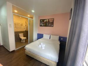 1 dormitorio con cama blanca y baño en Timez Business Hotel, en Kuala Lumpur