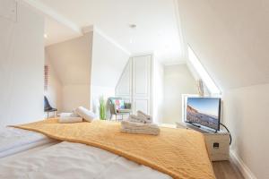 1 dormitorio con 1 cama grande y TV. en Appartement Sylter Glück, en Westerland