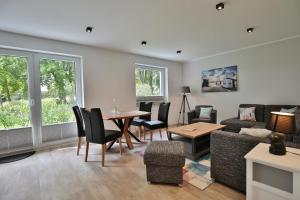 a living room with a couch and a table and chairs at Haus am Seehof 9 Ferienwohnung Ostseeliebe Nr 3 in Sierksdorf