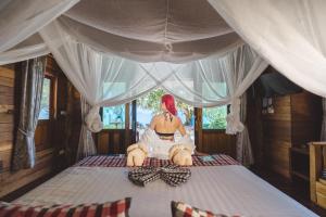 a woman sitting on top of a bed at Thapwarin Resort - Green Hotel in Ko Ngai