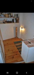 Habitación con suelo de madera, mesa y lámpara. en Tout confort en plein centre, en Le Vigan