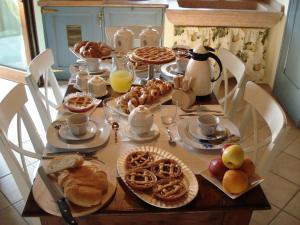 - une table remplie d'aliments pour le petit-déjeuner, de café et de jus d'orange dans l'établissement B&B I fiori di Marianna, à Bergame
