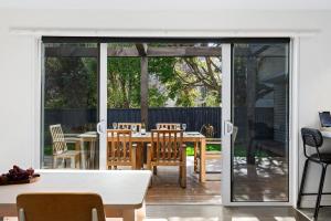 a screened in porch with a table and chairs at Whakata on McBride in Queenstown