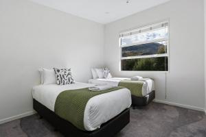 a bedroom with two beds and a window at Whakata on McBride in Queenstown