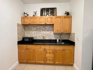 a kitchen with wooden cabinets and a sink at Paradise in Brandon with luxurious 6 person Spa in Brandon