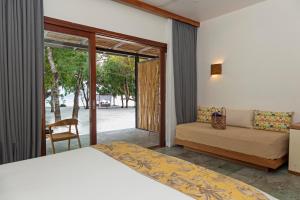 a bedroom with a bed and a couch and a window at ISLAND CENTER POINT in Koh Rong Sanloem