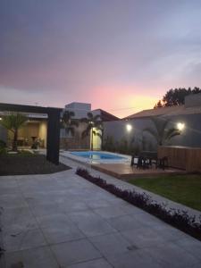 a backyard of a house with a pool at dusk at Casa Bela no Rita Vieira in Campo Grande
