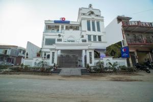 een wit gebouw met een bord erop bij OYO Flagship 63319 Hotel Corinthian in Rudrapur