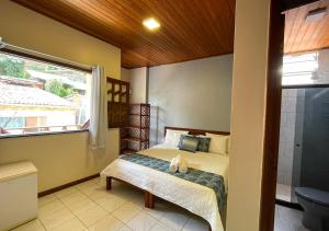 a small bedroom with a bed and a window at Pousada Estevao in Morro de São Paulo