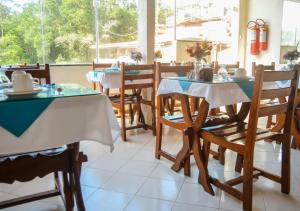 a dining room with tables and chairs in a restaurant at Pousada Estevao in Morro de São Paulo