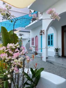 a courtyard with pink flowers in front of a house at VYA homestay Huế in Thôn Lại Thê