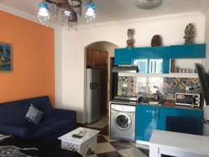 a living room with a couch and a washing machine at Exoticky apartman in Hurghada