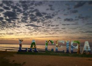 un cartello per la spiaggia con un tramonto sullo sfondo di Cozy Townhouse & Terrace/Pool a La Ceiba