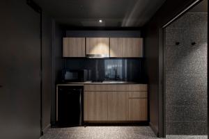 uma cozinha com armários de madeira e um lavatório em Citadines Walker North Sydney em Sydney