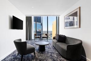 a living room with a couch and chairs and a table at Citadines Walker North Sydney in Sydney