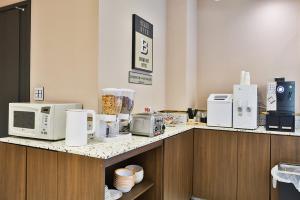 a kitchen with microwaves and appliances on a counter at Brown Dot Hotel Jeonggwan in Busan