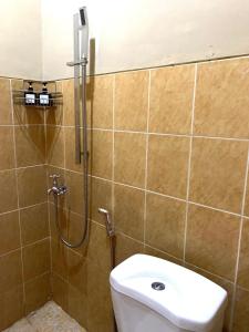 a bathroom with a shower with a toilet and a sink at Simple Home near Baturraden in Rempawah