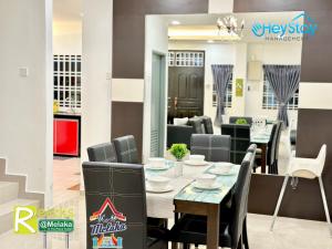 uma sala de jantar com mesa e cadeiras em GardenHomeStay TownArea Karaok Mahjong PrivatePool By HeystayManagement em Malaca