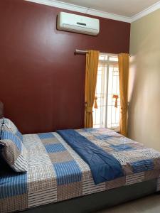 a bedroom with a bed and a window at Simple Home near Baturraden in Rempawah