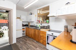 uma cozinha com electrodomésticos brancos e armários de madeira em Kaniere Hotel em Hokitika