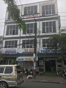 a building with a van parked in front of it at Khách sạn Thiên Phúc in Cà Mau