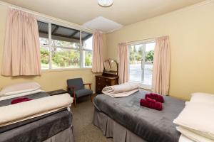 a bedroom with two beds and a window at Kaniere Hotel in Hokitika
