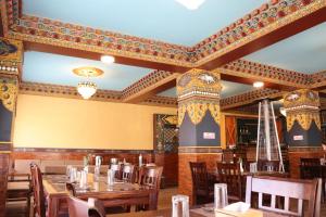 Hotel De Purang في Muktināth: غرفة طعام مع طاولات وكراسي خشبية
