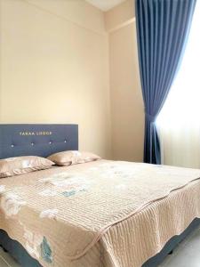 sypialnia z dużym łóżkiem z niebieską zasłoną w obiekcie Taraa Lodge PutrajayaMuslim w mieście Putrajaya