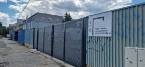 a fence with a sign on the side of a building at Privat Prešov in Prešov