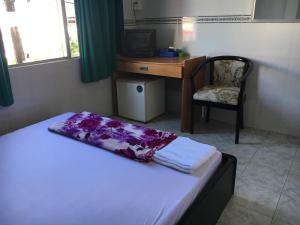 a bedroom with a bed and a desk and a chair at Khách sạn Thiên Phúc in Cà Mau