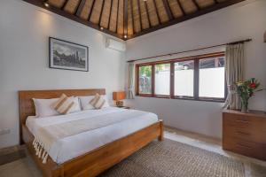 a bedroom with a large bed and a window at Jasmina Estate by Villas Direct Bali in Seminyak +44 photos