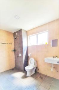 y baño con aseo, ducha y lavamanos. en Taraa Lodge PutrajayaMuslim en Putrajaya