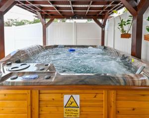 een jacuzzi in een achtertuin met een pergola bij Paradise in Brandon with luxurious 6 person Spa in Brandon