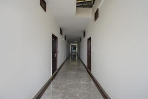 un pasillo de una habitación vacía con paredes y suelos blancos en Flagship 71214 Hotel Welcome Inn en Ludhiana