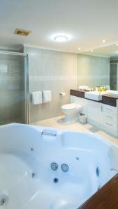 a large bathroom with a tub and a toilet at Waters Edge Apartment Cairns in Cairns