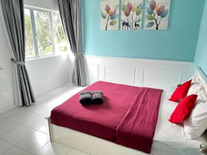 1 dormitorio con 1 cama con 2 zapatillas en A3A Oastel coLiving, en Tanah Rata