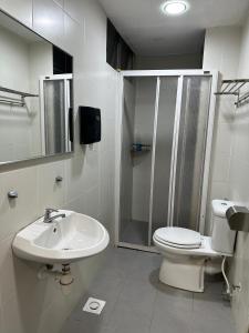 a bathroom with a toilet and a shower and a sink at A3A Oastel coLiving in Tanah Rata