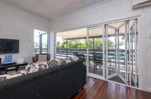 a living room with a couch and a balcony at The Cottage 16 Clarke Street Bargara in Bargara