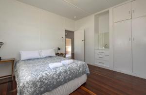 a bedroom with a bed with two towels on it at The Cottage 16 Clarke Street Bargara in Bargara