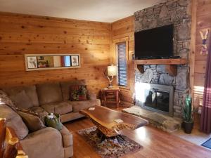 a living room with a couch and a fireplace at Adventure in the woods @ Seven Springs in Champion