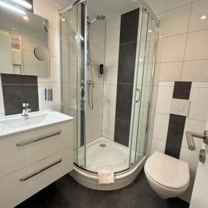 y baño con ducha, aseo y lavamanos. en Nordseehotel Wilhelmshaven, en Wilhelmshaven