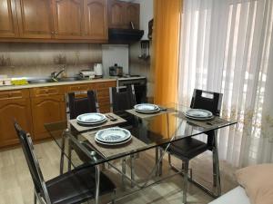- une cuisine avec une table en verre, des chaises, une table et des chaises dans l'établissement STOUDIO VOUL, à Alexandroúpolis