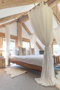 1 dormitorio con 1 cama grande y cortinas en Wild Nurture Eco Luxury Offgrid Log Cabin, en Fort William