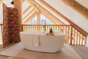 una gran bañera blanca en una habitación en Wild Nurture Eco Luxury Offgrid Log Cabin en Fort William