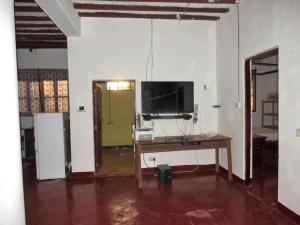 a room with a table and a tv on a wall at Room in Guest room - Spacy Bedroom W In Shared House in Jambiani