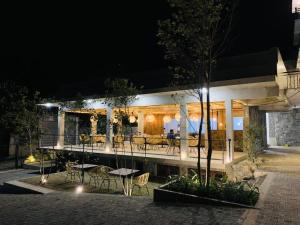 a restaurant with tables and chairs at night at 88th - ELLA in Ella